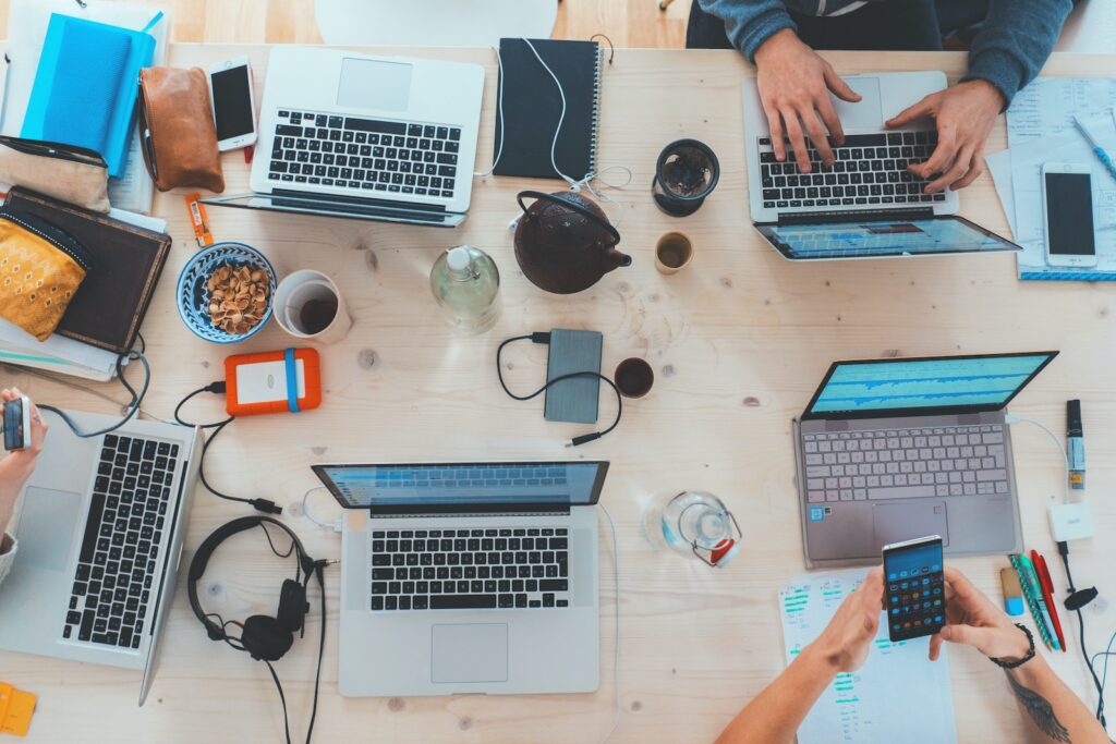 Optimize Your Code - people sitting down near table with assorted laptop computers